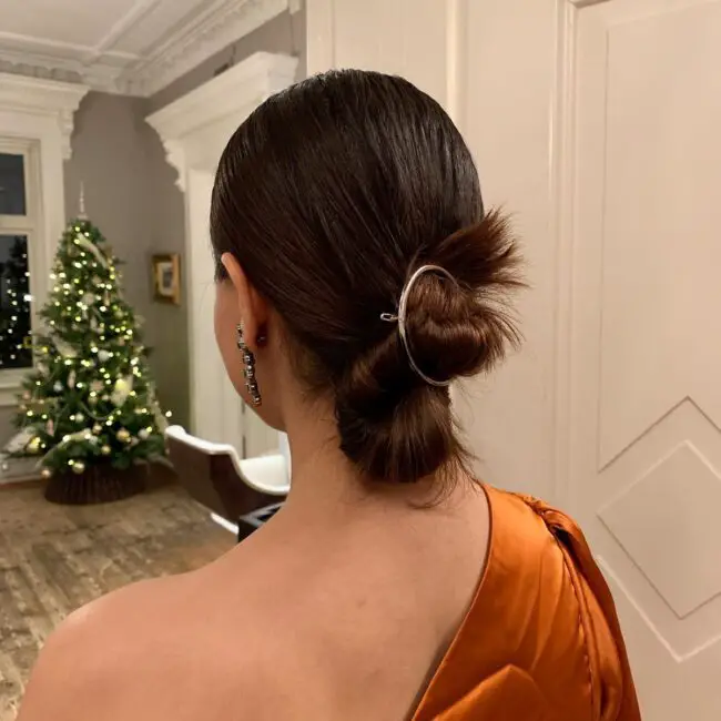 Sleek Low Bun with Metallic Accent Pin